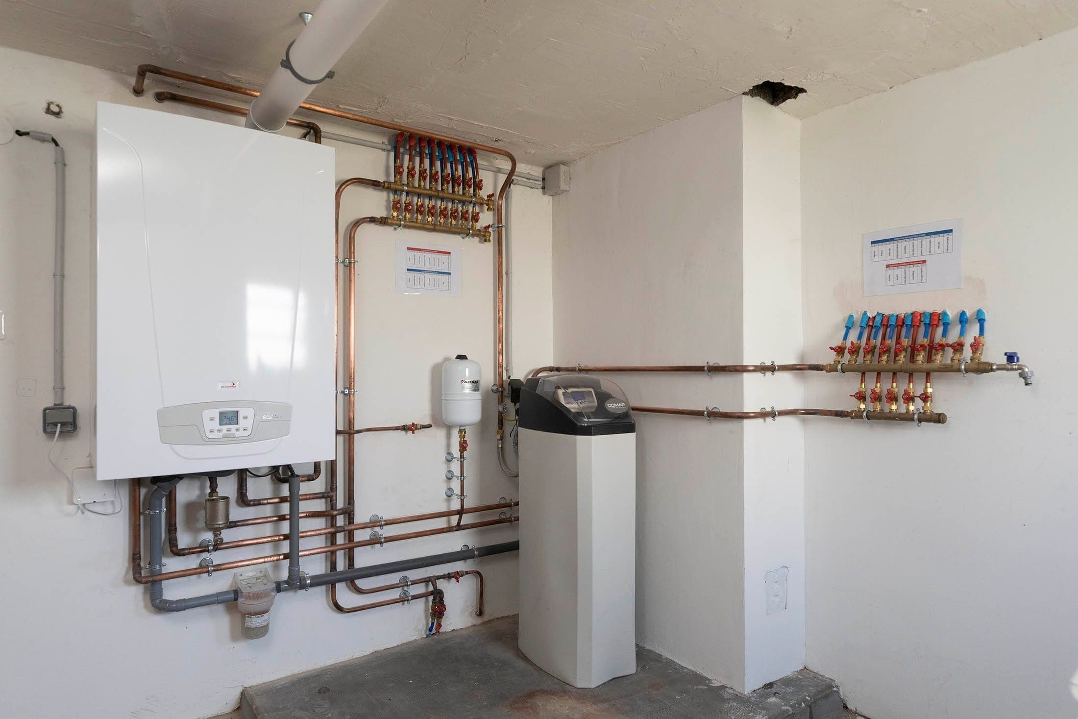 Salle technique avec chaudière, adoucisseur et collecteurs — installation réalisée par Yce Confort