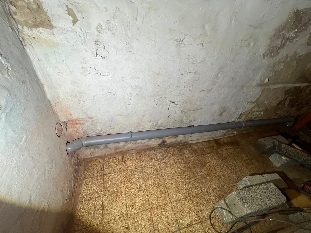Canalisation PVC grise posée au sol pour égoutage — raccordement Yce Confort