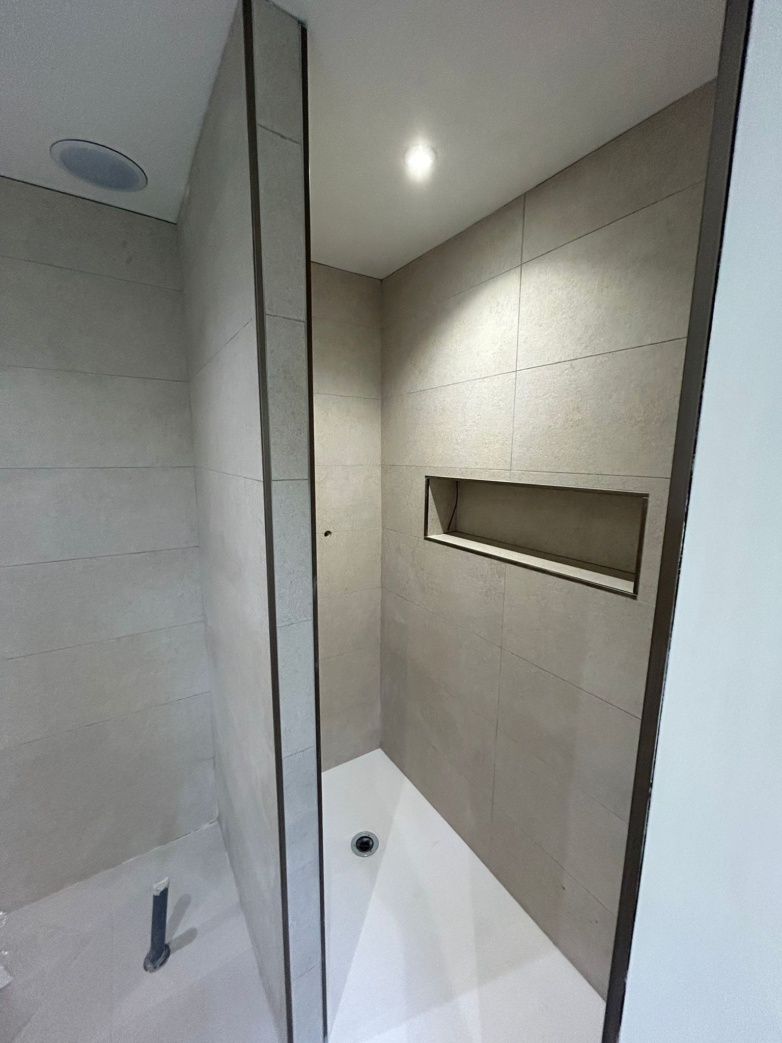 Espace douche avec niche intégrée et carrelage beige