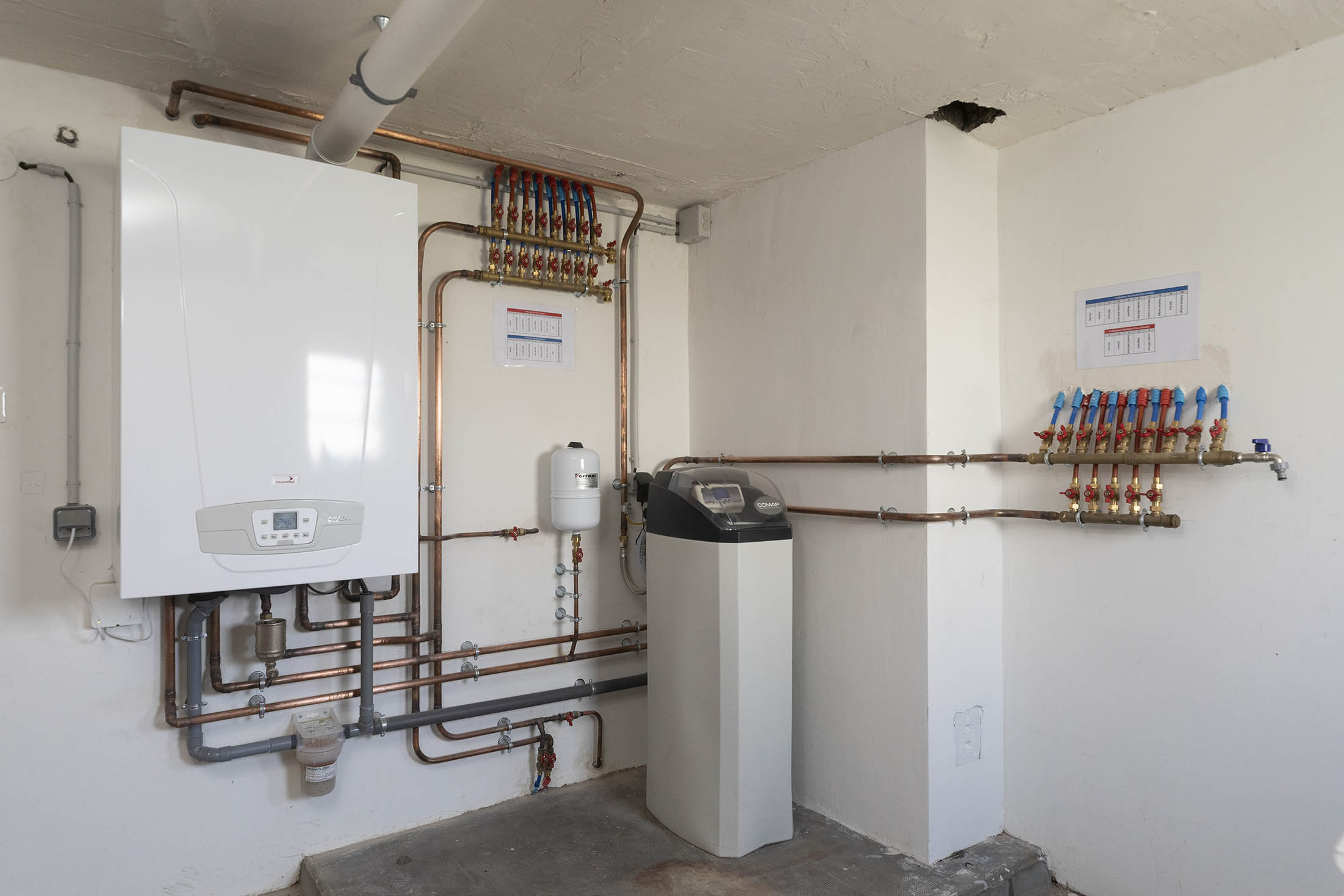 Salle technique complète avec chaudière, adoucisseur et collecteurs — Yce Confort